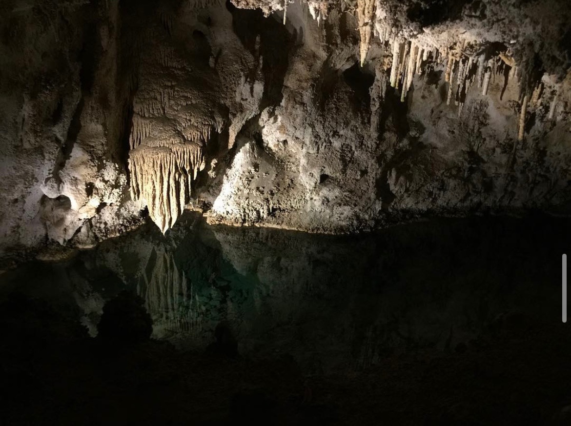 Stalactites above a dark pool in Carslbad Caverns, NM